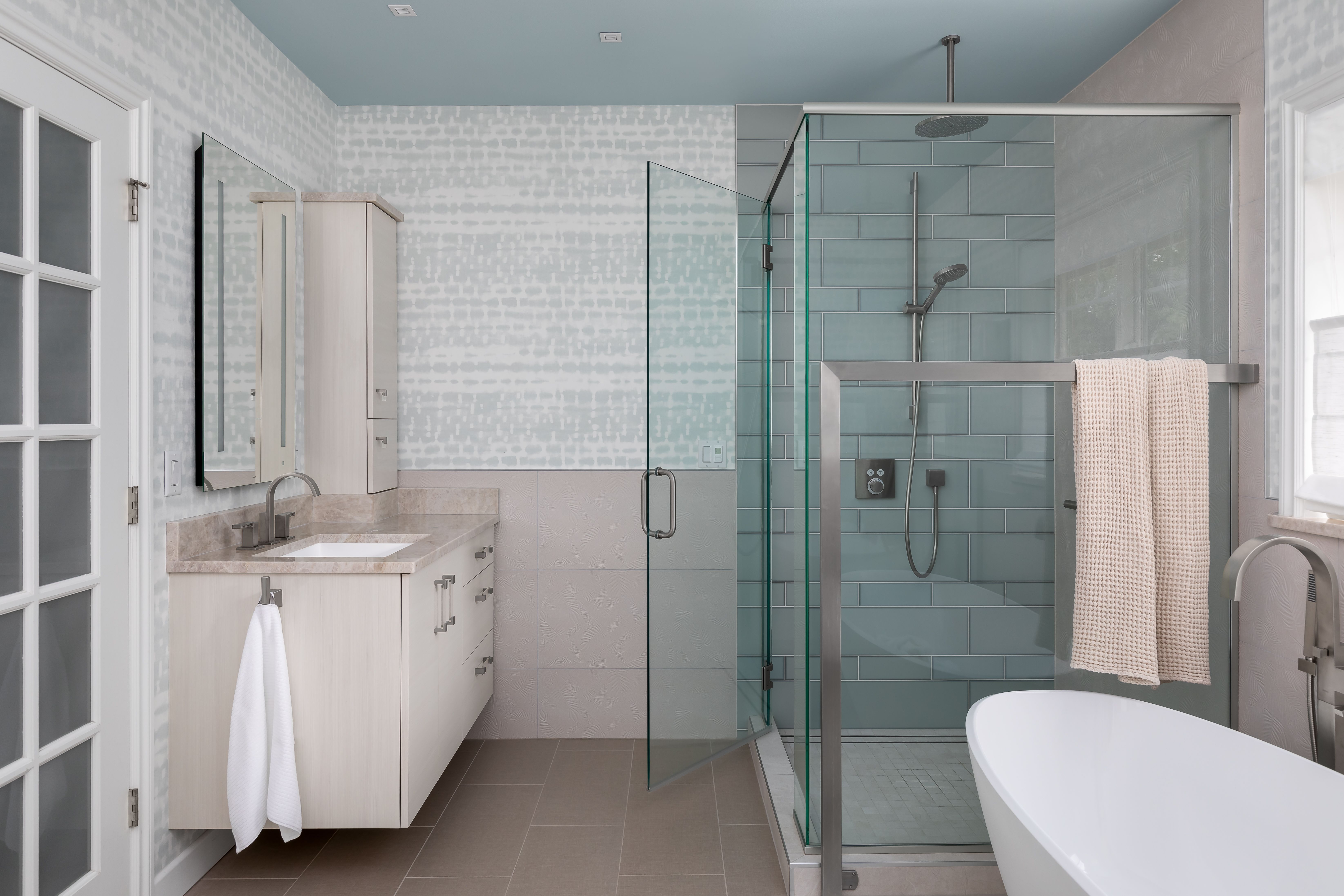 A spa-inspired primary bath remodel in Bellevue, WA — his-and-hers vanity, improved storage, and a calming palette of watery textures and motifs.