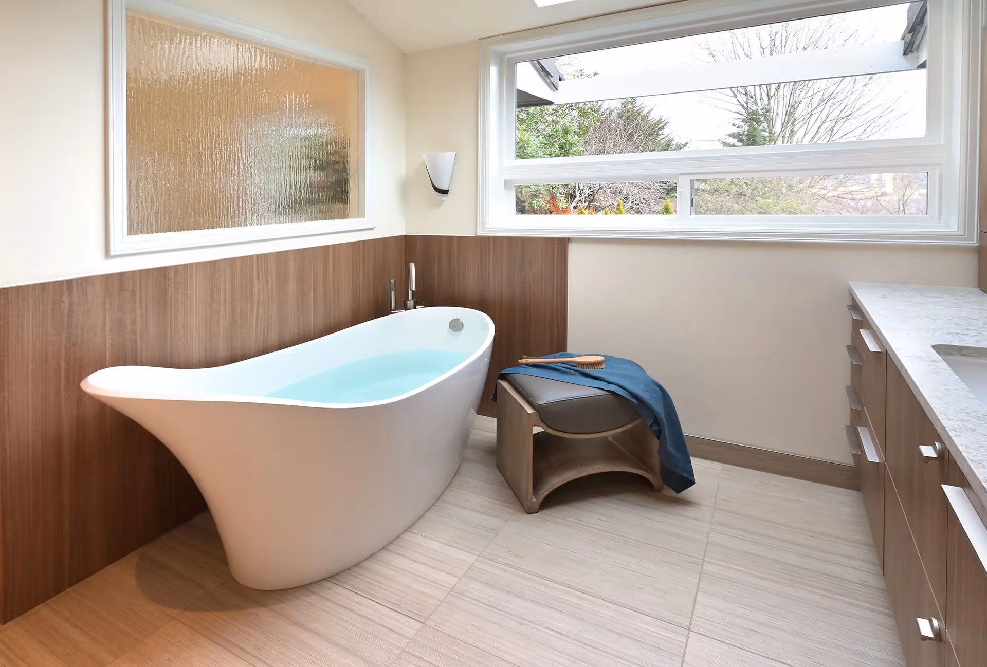 A nature-inspired master bath remodel on Mercer Island — stand-alone tub, his-and-her vanities, and panoramic water views through new horizontal windows.