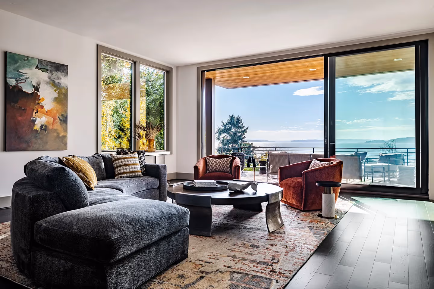 A whole-home transformation in Seattle's Magnolia neighborhood — living room, kitchen, deck, and dining room with sweeping water views and local art.