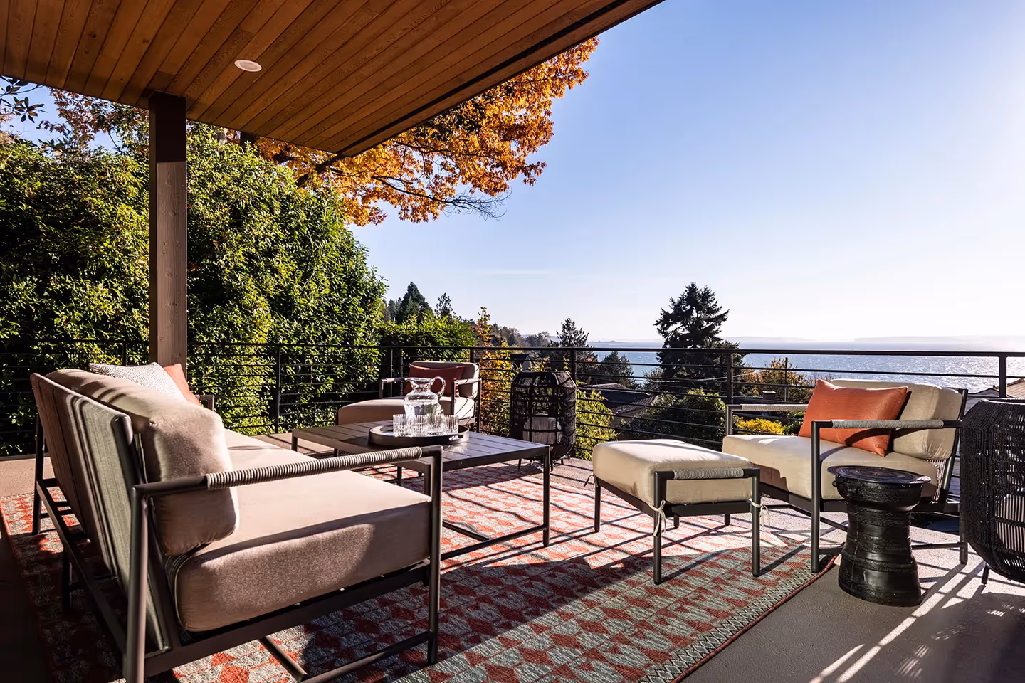 A whole-home transformation in Seattle's Magnolia neighborhood — living room, kitchen, deck, and dining room with sweeping water views and local art.