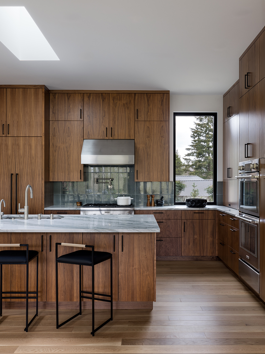 A Zen-inspired full remodel of a mid-century modern home in North Seattle — bookmatched cabinetry, quartzite countertops, and custom furnishings.