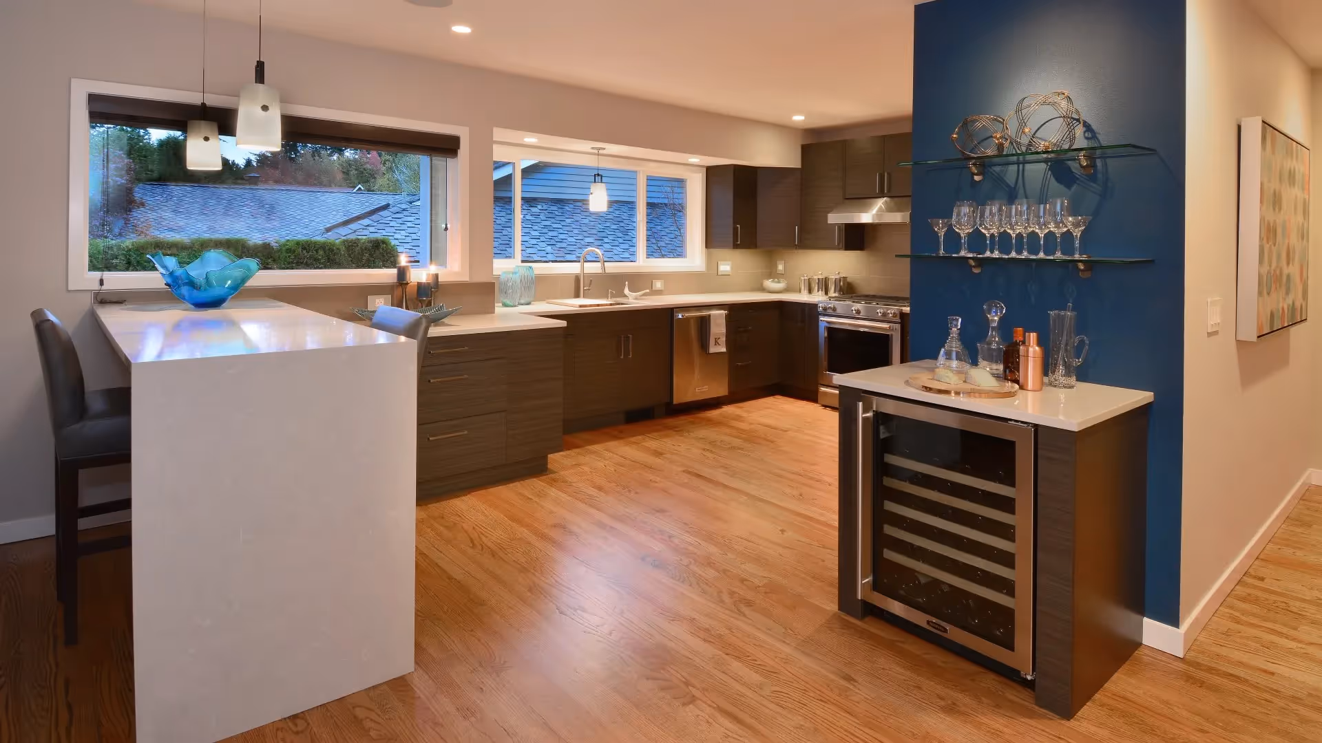 A Remodeling Excellence Award-winning kitchen and family room remodel in Mill Creek — open floorplan, wine storage, and a custom waterfall quartz table.