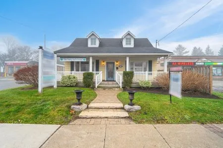 Small office building with a front porch, two dormer windows, and signs for The Tarry Duvall and Air Wireless.