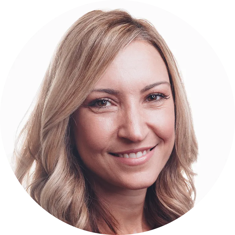 Close-up of a smiling woman with blonde hair against a white background.