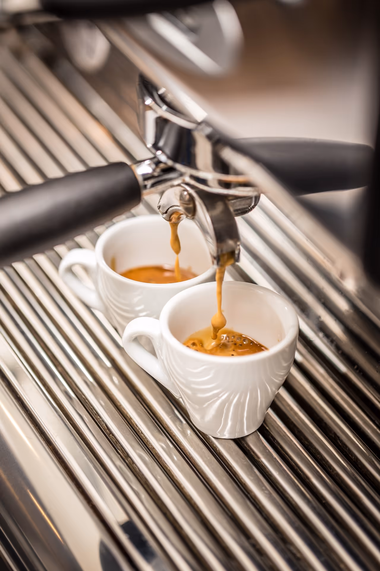 Une machine à café avec deux expressos entrain de se servir.