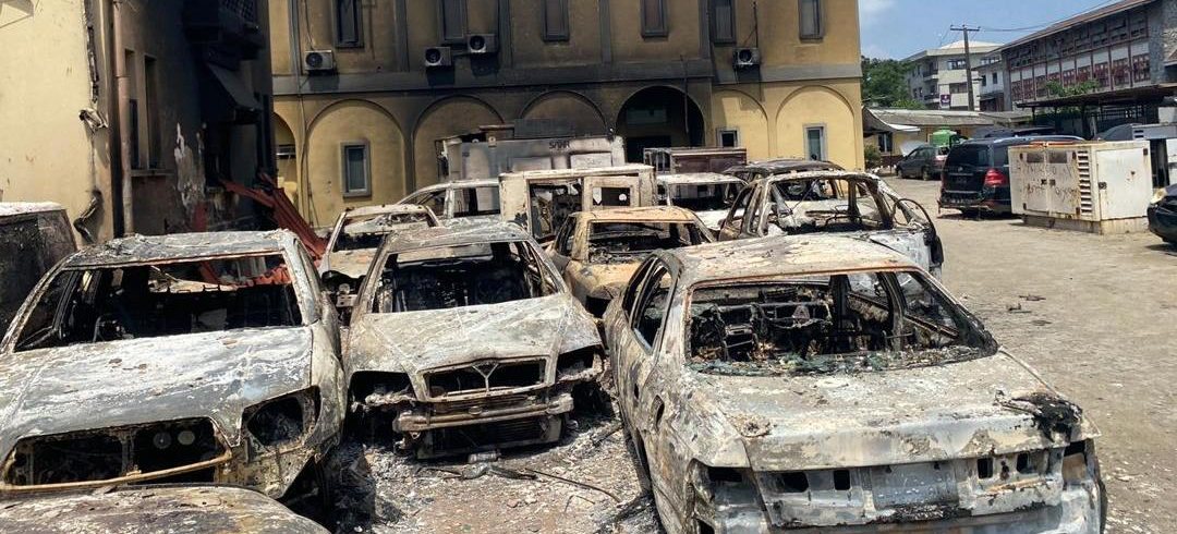 Fire-damaged vehicles and building after civil unrest