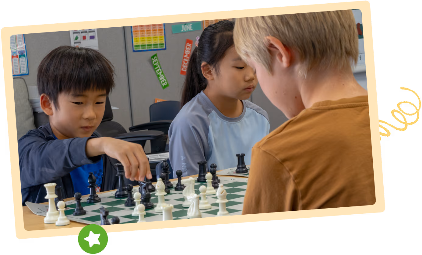 Three children focus intently on their chess matches during a class at San Jose campus