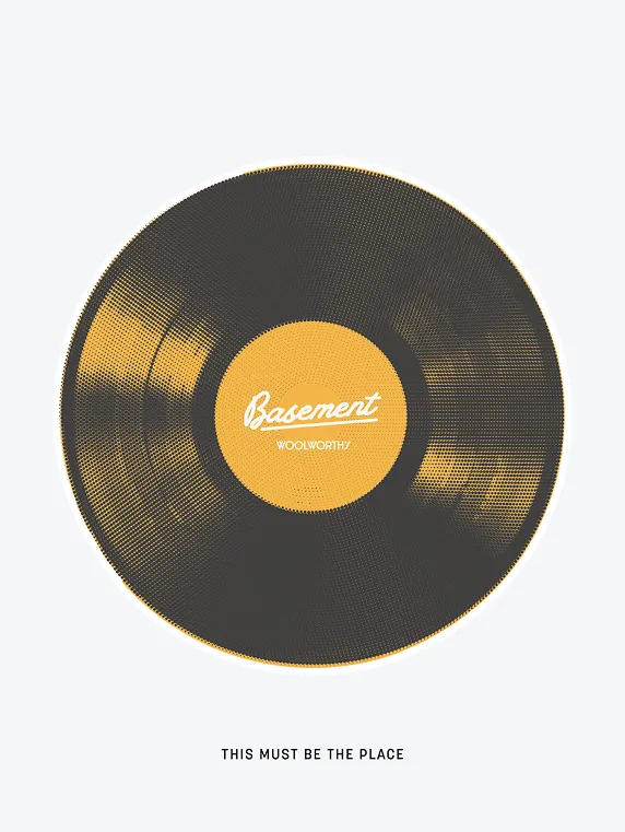 Black vinyl record with yellow label reading 'Basement Woolworths' and text below saying 'This must be the place'.