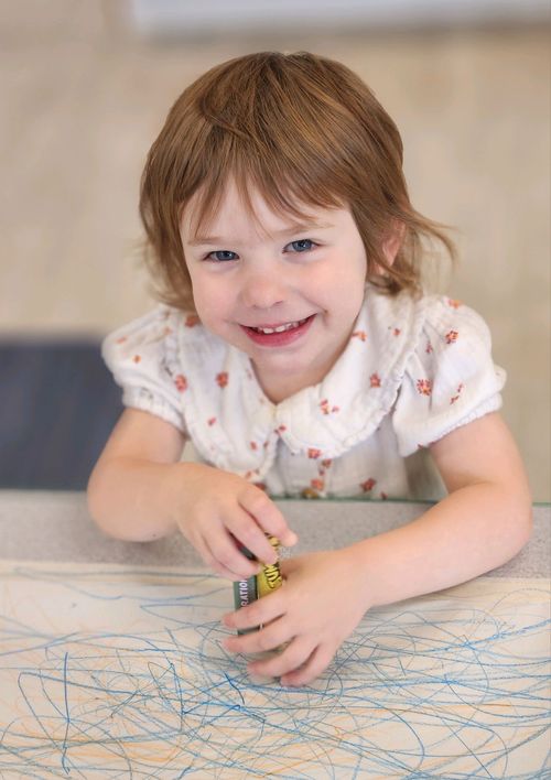 A cute kid drawing with crayons