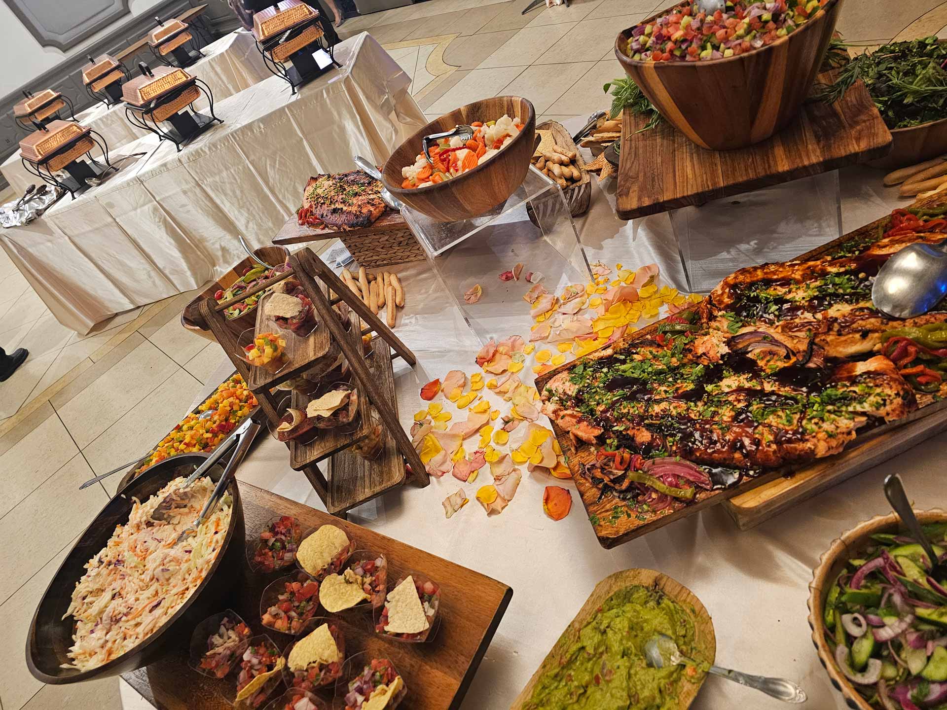 A buffet table filled with a variety of dishes, including salads, meats, and desserts, inviting guests to serve themselves.