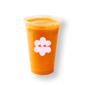 Ein transparenter Becher, gefüllt mit leuchtend orangefarbenem Saft und verziert mit einem weißen Blumenlogo, hebt sich von einem schlichten schwarzen Hintergrund ab.