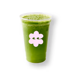 Ein grüner Smoothie in einem transparenten Becher mit einem pinkfarbenen Blumenlogo vor schwarzem Hintergrund. Das Getränk wirkt frisch und lebendig.