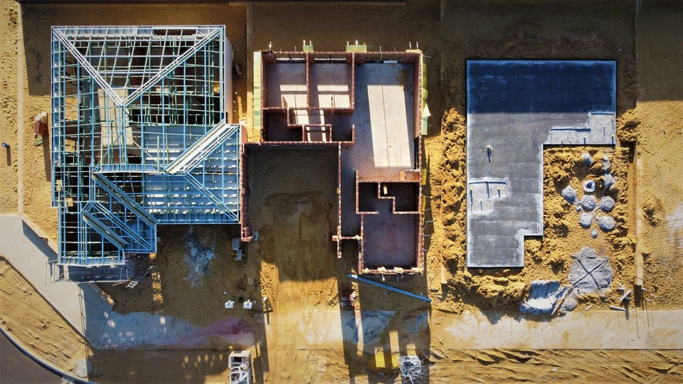 Aerial view of new build construction with steel frame and brick foundations