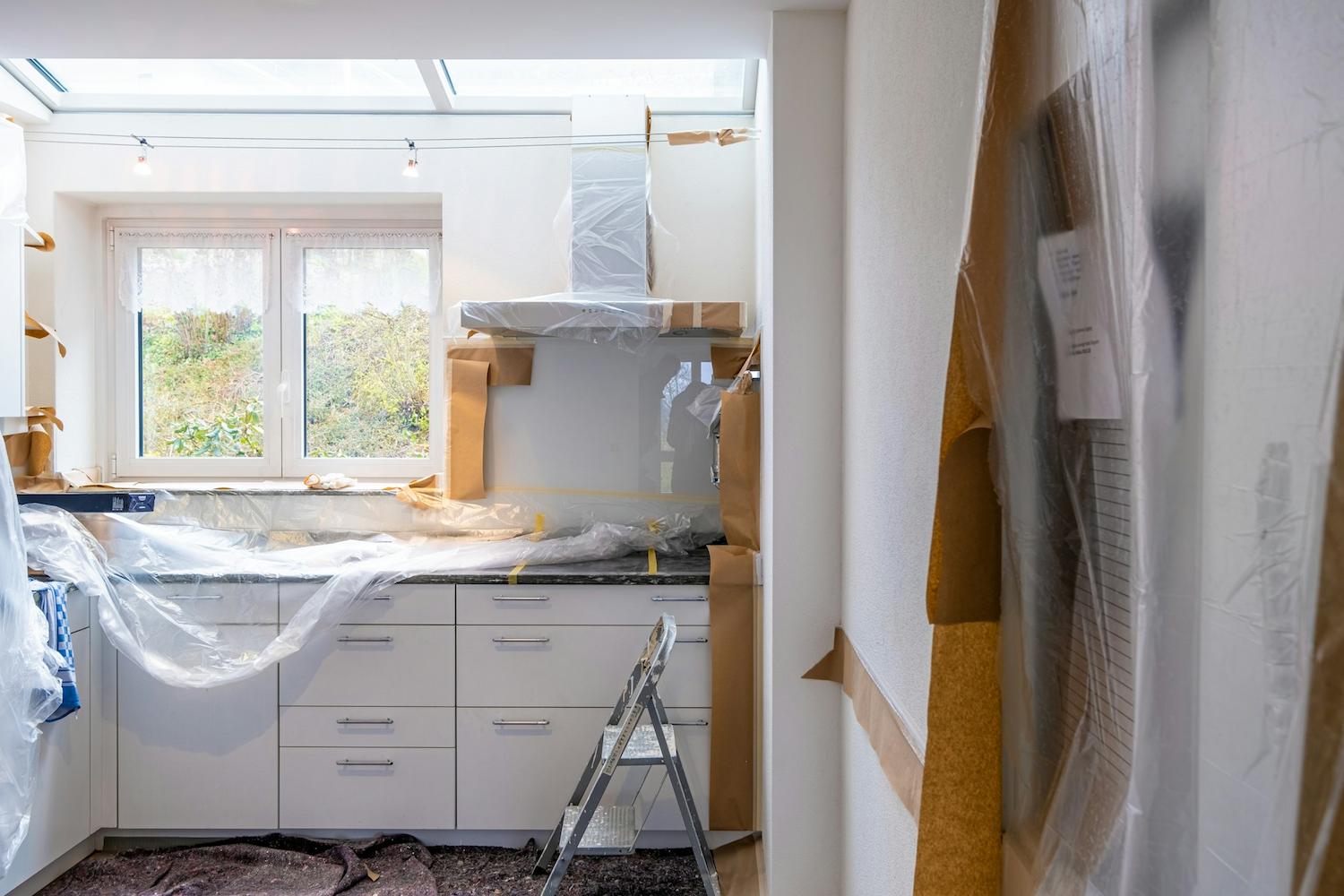 Off-plan kitchen being fitted out under protective sheeting
