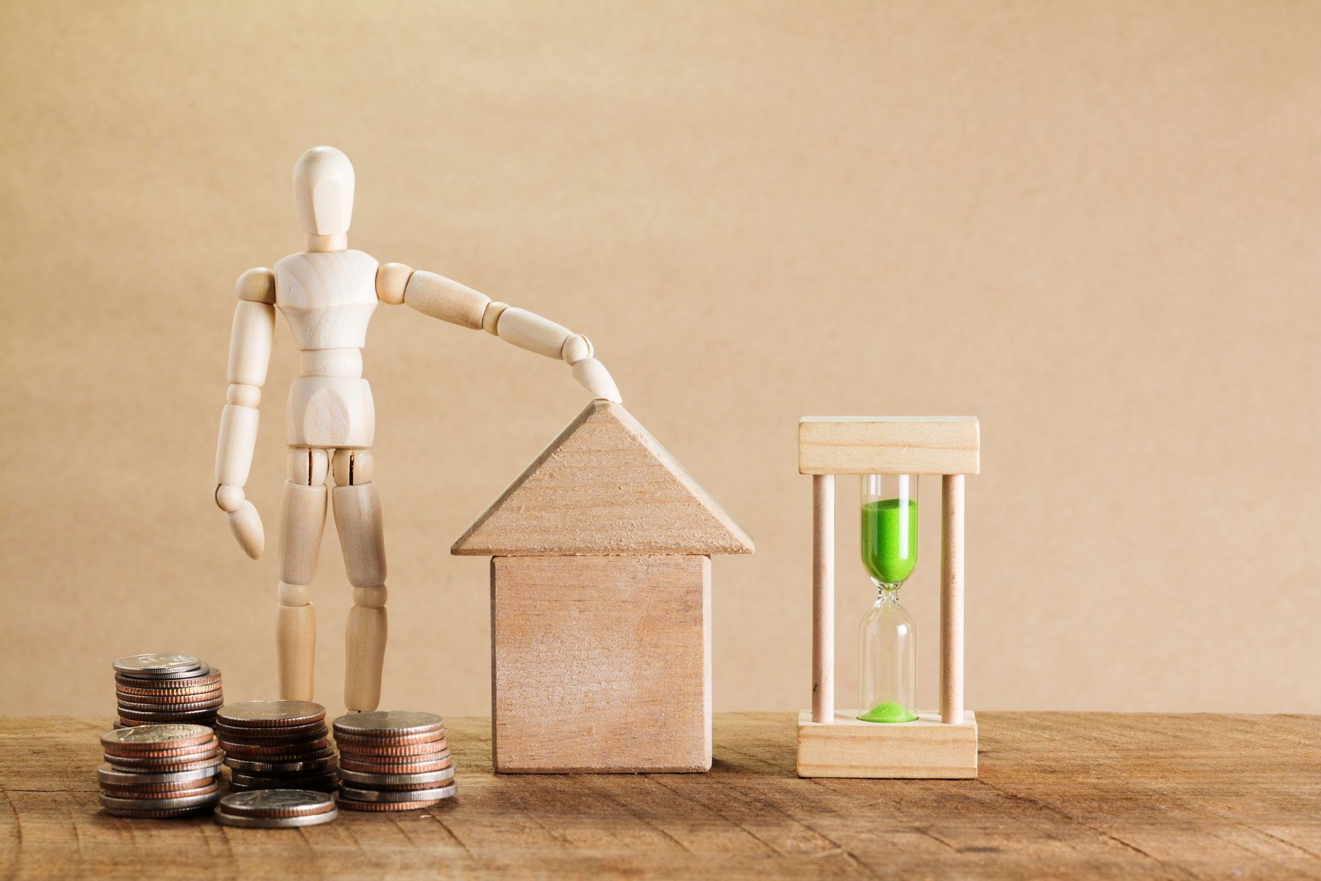 Model house, coin stacks and a green hourglass illustrating buy-to-let equity release and the time it takes to access funds