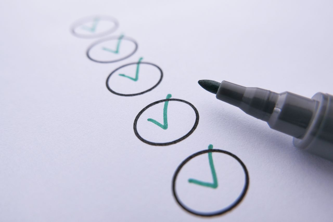 Checklist with five green ticks and a marker pen, representing bridging loan eligibility criteria