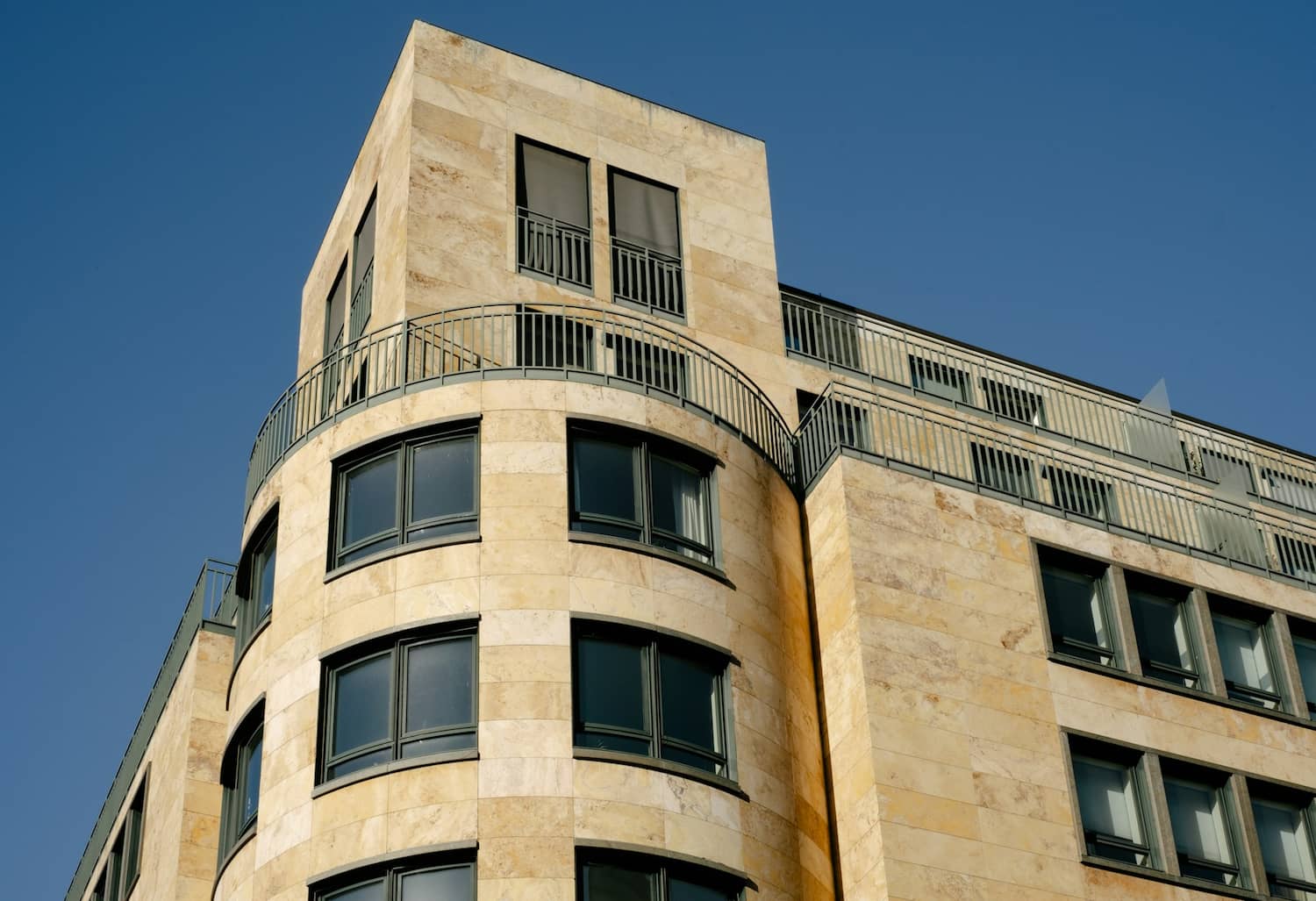 Modern apartment block against a blue sky, showing the shared roof and stairwell that make flats leasehold
