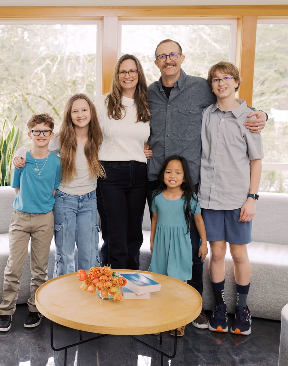 A family of 6 poses for a photo in the lobby of the church. 