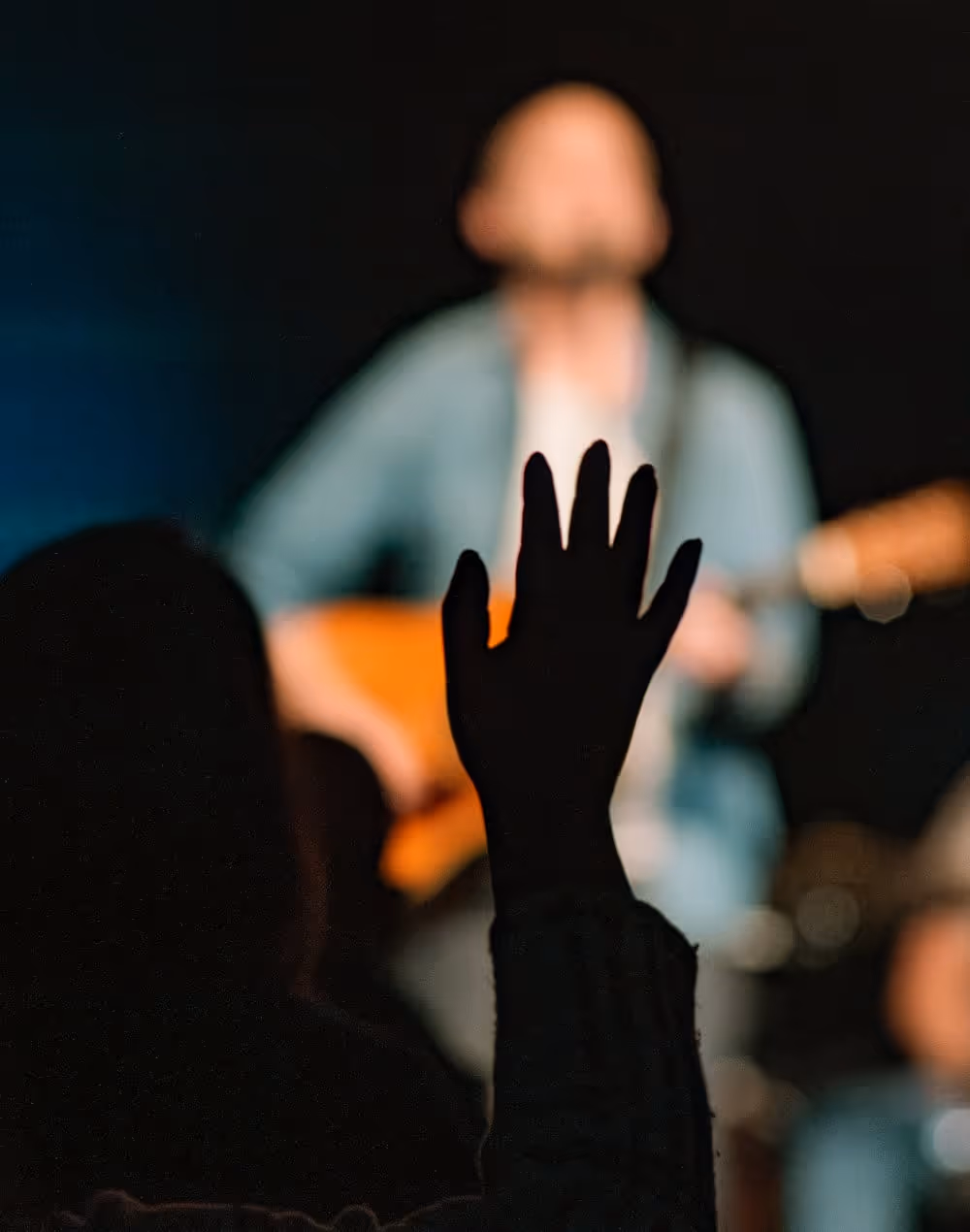 a hand raised in worship during a church service