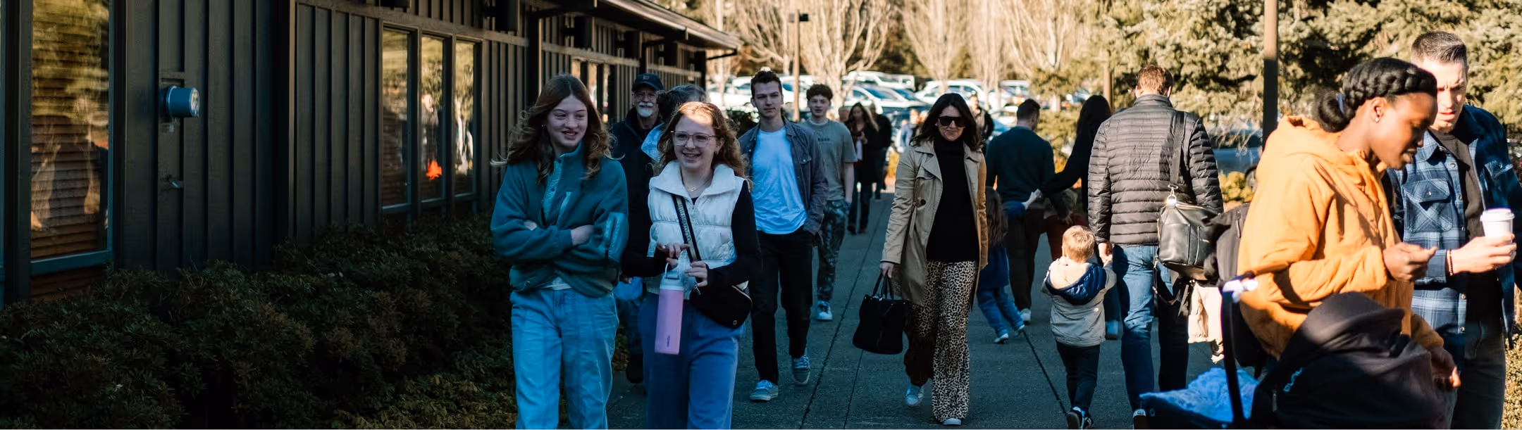 A group of people walking down a sidewalk.