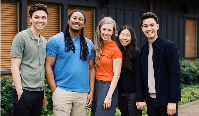 a group of young adults smile and pose