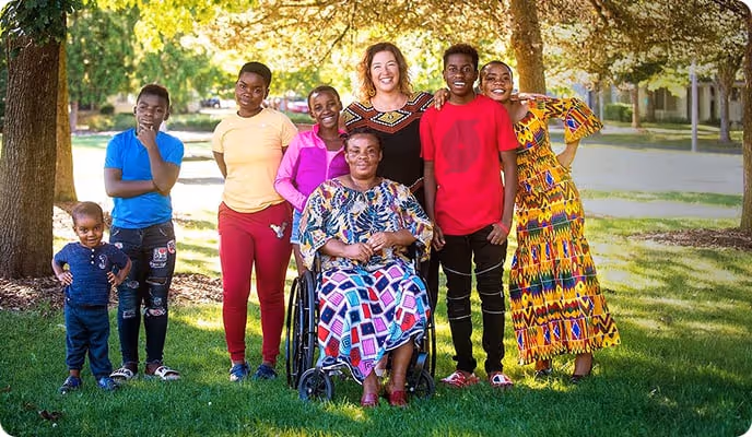A family of seven stands outside for a picture. 