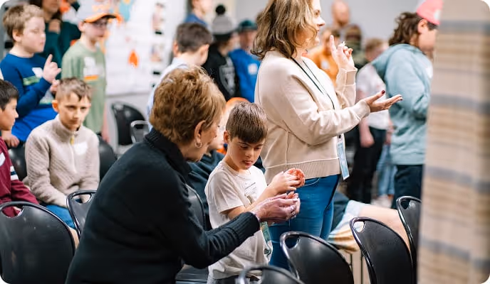 a women helps a young boy during kids church