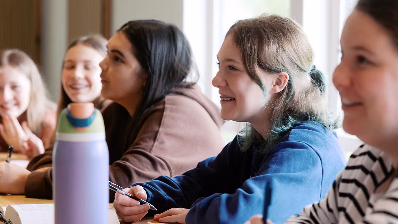 students sitting with each other at a desk