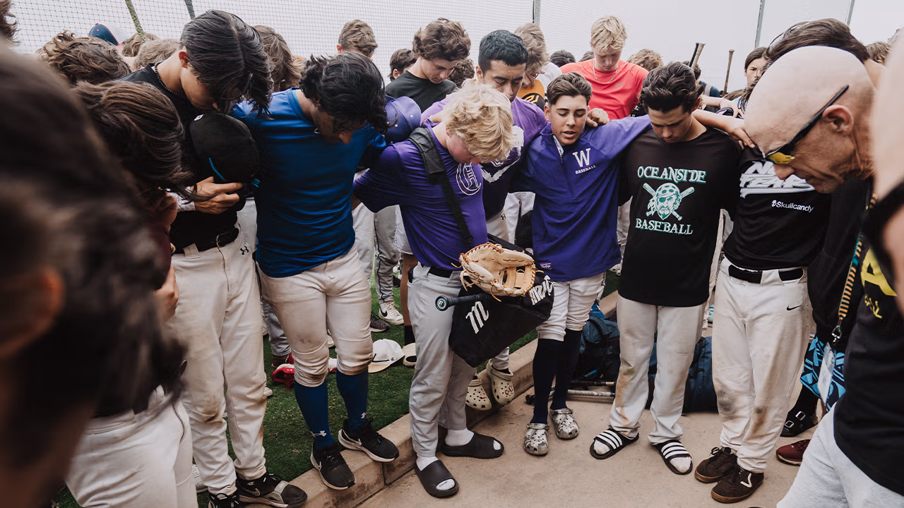 a group of young athletes praying together
