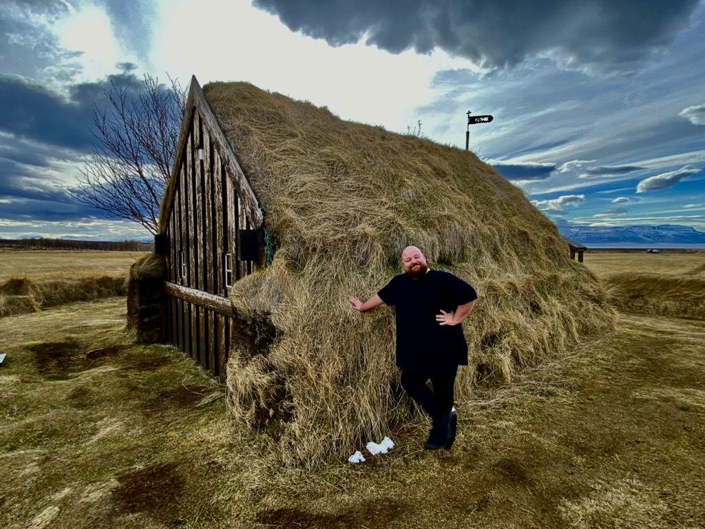 Elliot Jones standing next to a house in Iceland