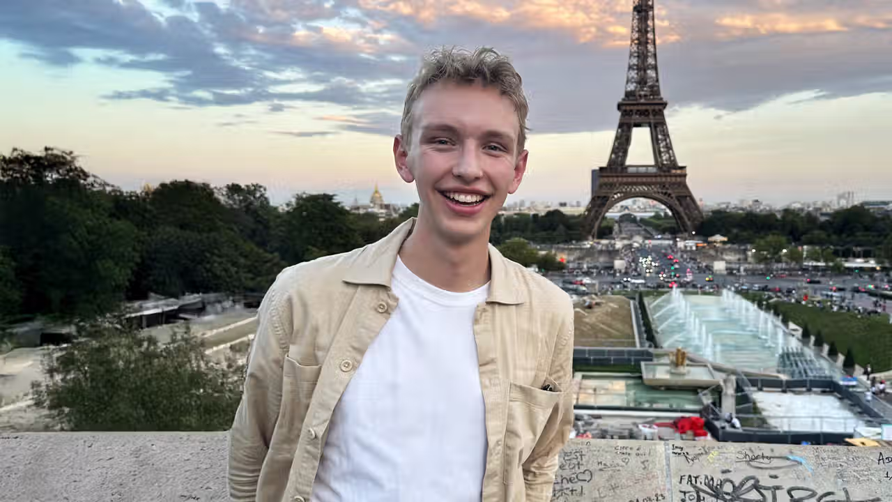 Jonah standing in front of the Eiffel Tower