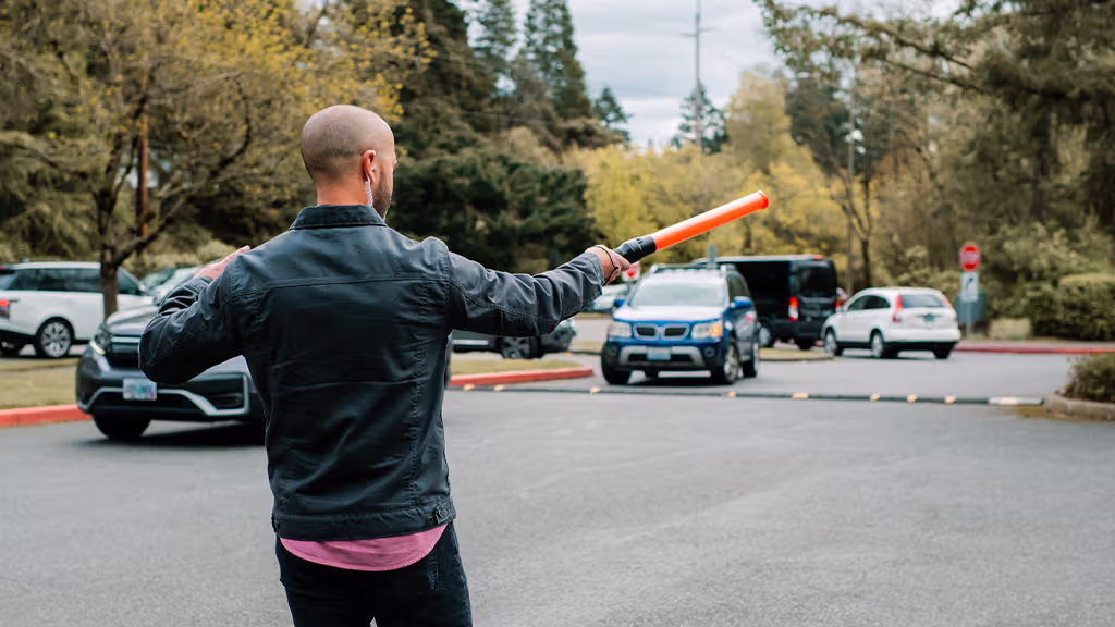 A man guiding traffic through a parking lot