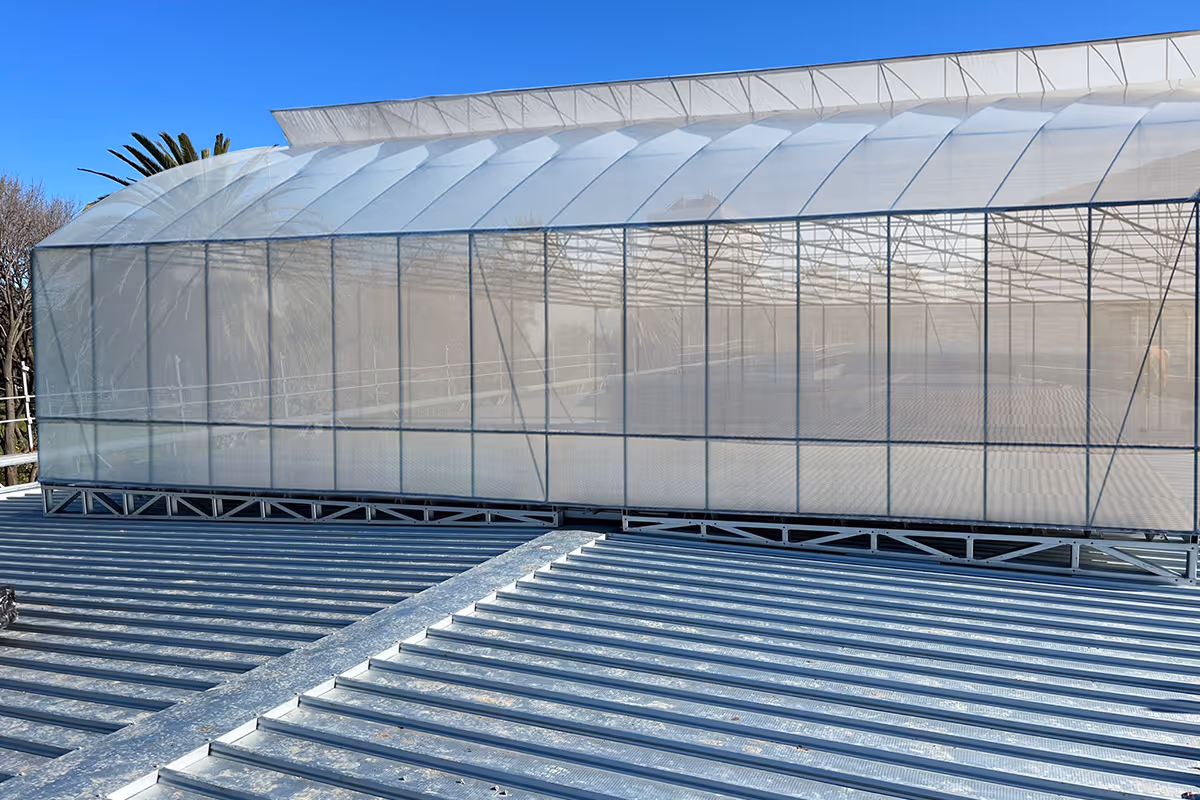 Rooftop greenhouse structure with translucent panels.