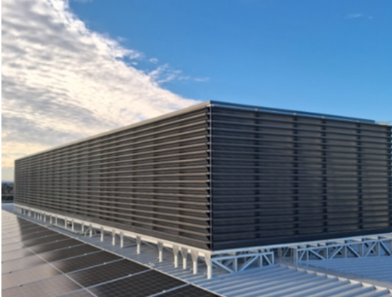 Dark louvred enclosure installed on a data centre rooftop.