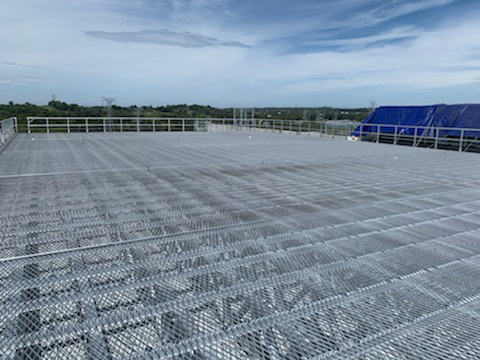 Wide steel-grating platform on a data centre rooftop.
