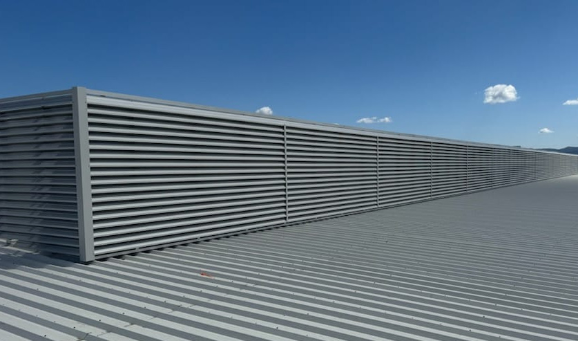 Close-up of curved metal louvre blades on a rooftop.