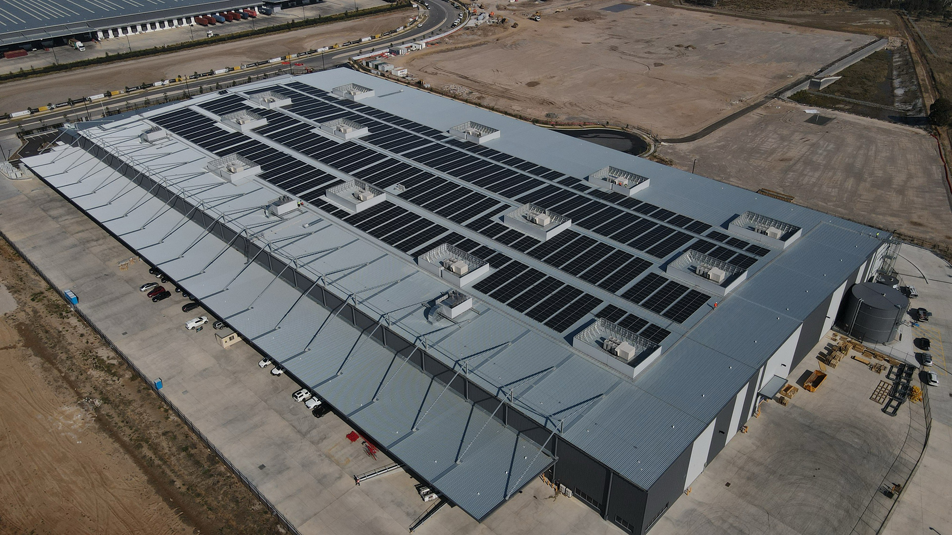 Rooftop data centre with long rows of mechanical equipment, viewed from above.