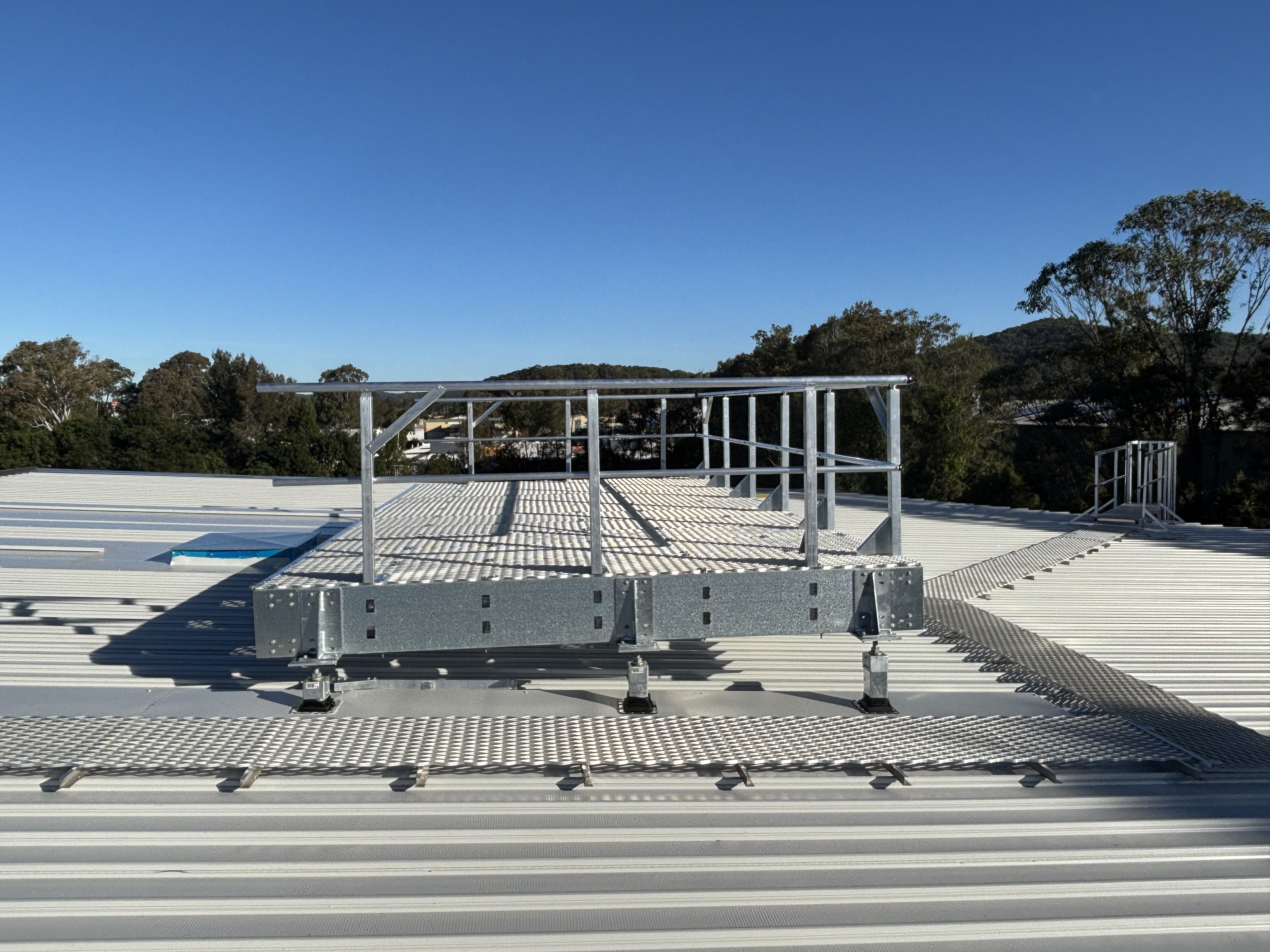 Rooftop guardrail and HVAC platform in daylight
