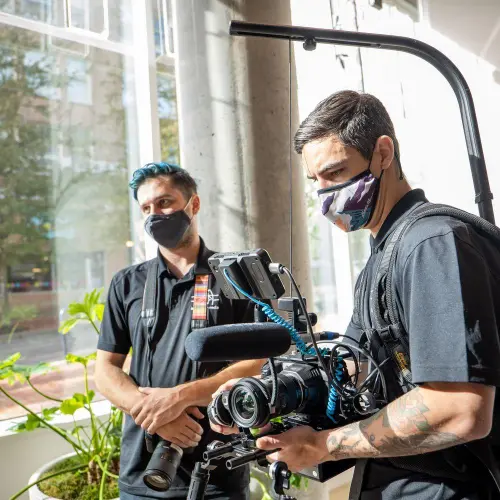 video production pricing breakdown professional crew on set reviewing shot list and camera equipment