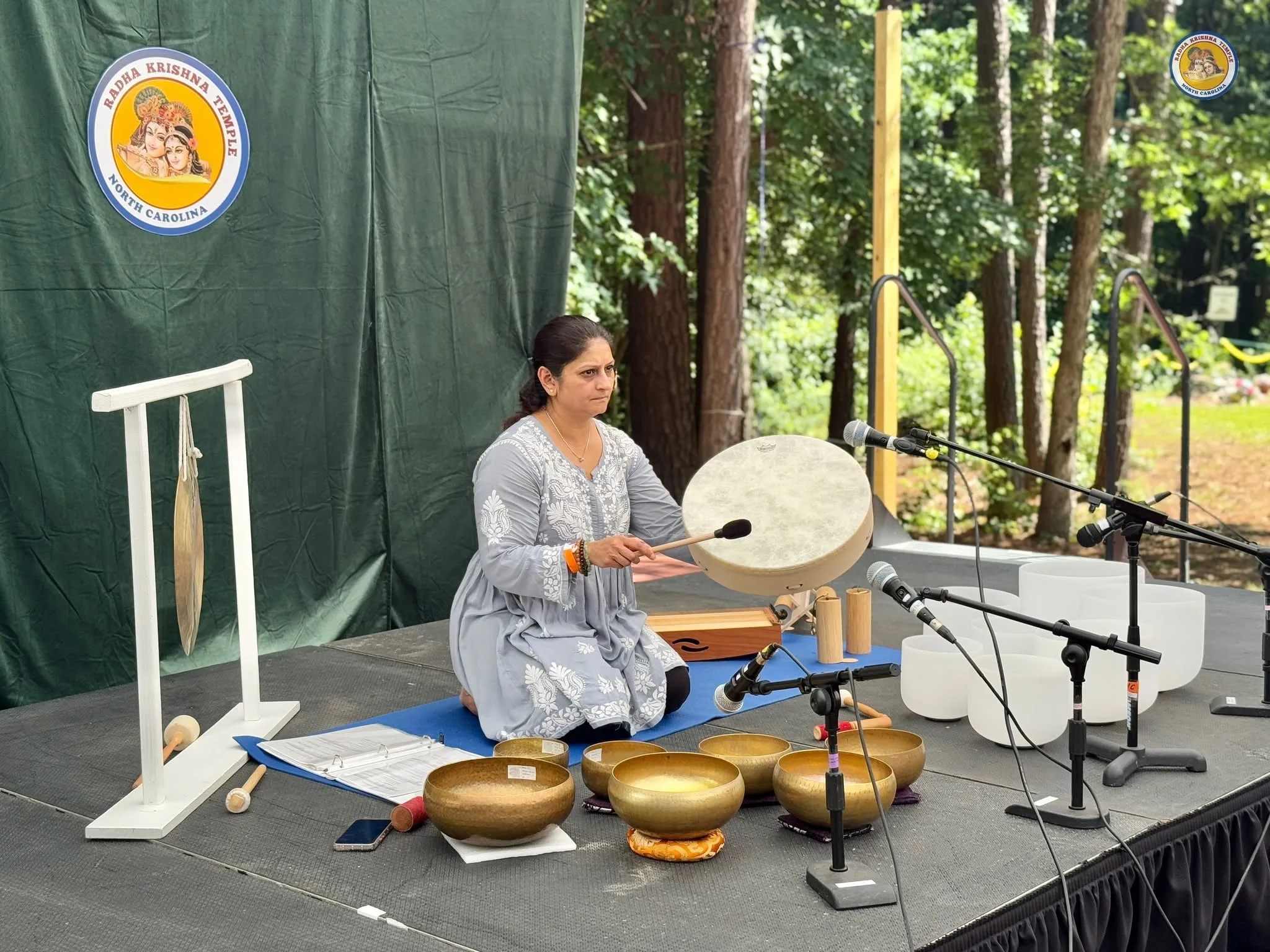 Practitioner playing frame drum during sound healing at NC Yoga Fest