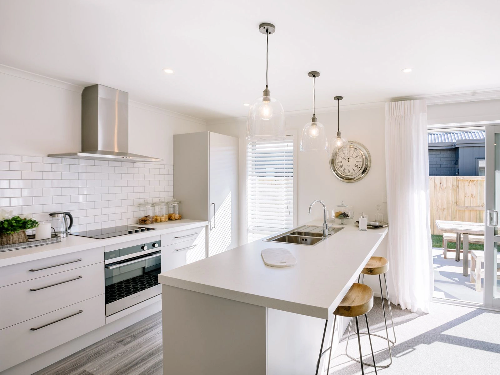  modern kitchen with large benchtops and tiled splashback