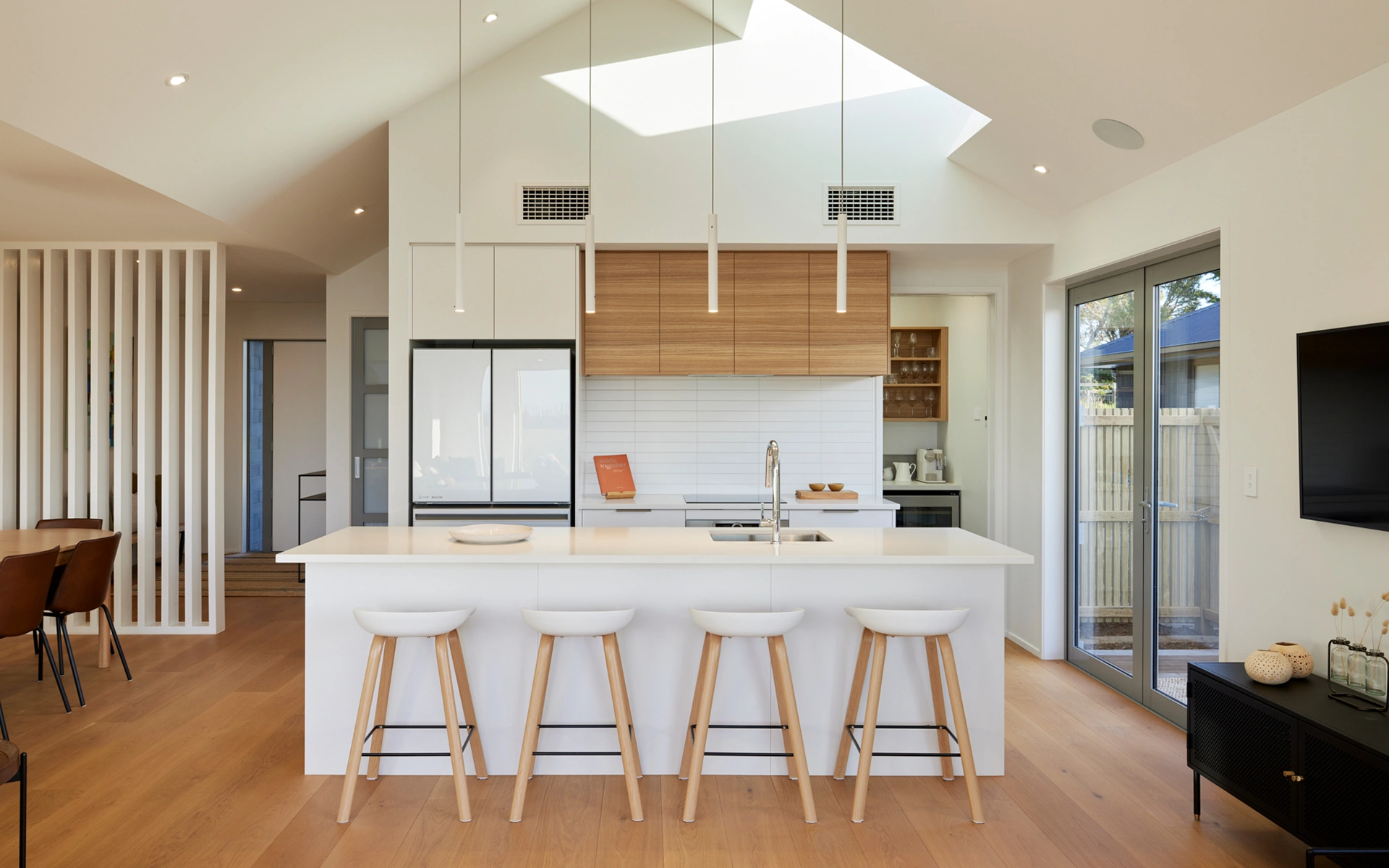 Modern minimalist kitchen with white island and wooden accents