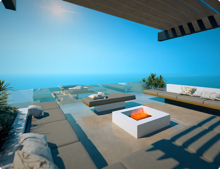 Modern outdoor patio with cushioned seating around a fire pit overlooking a clear blue sky and sea.