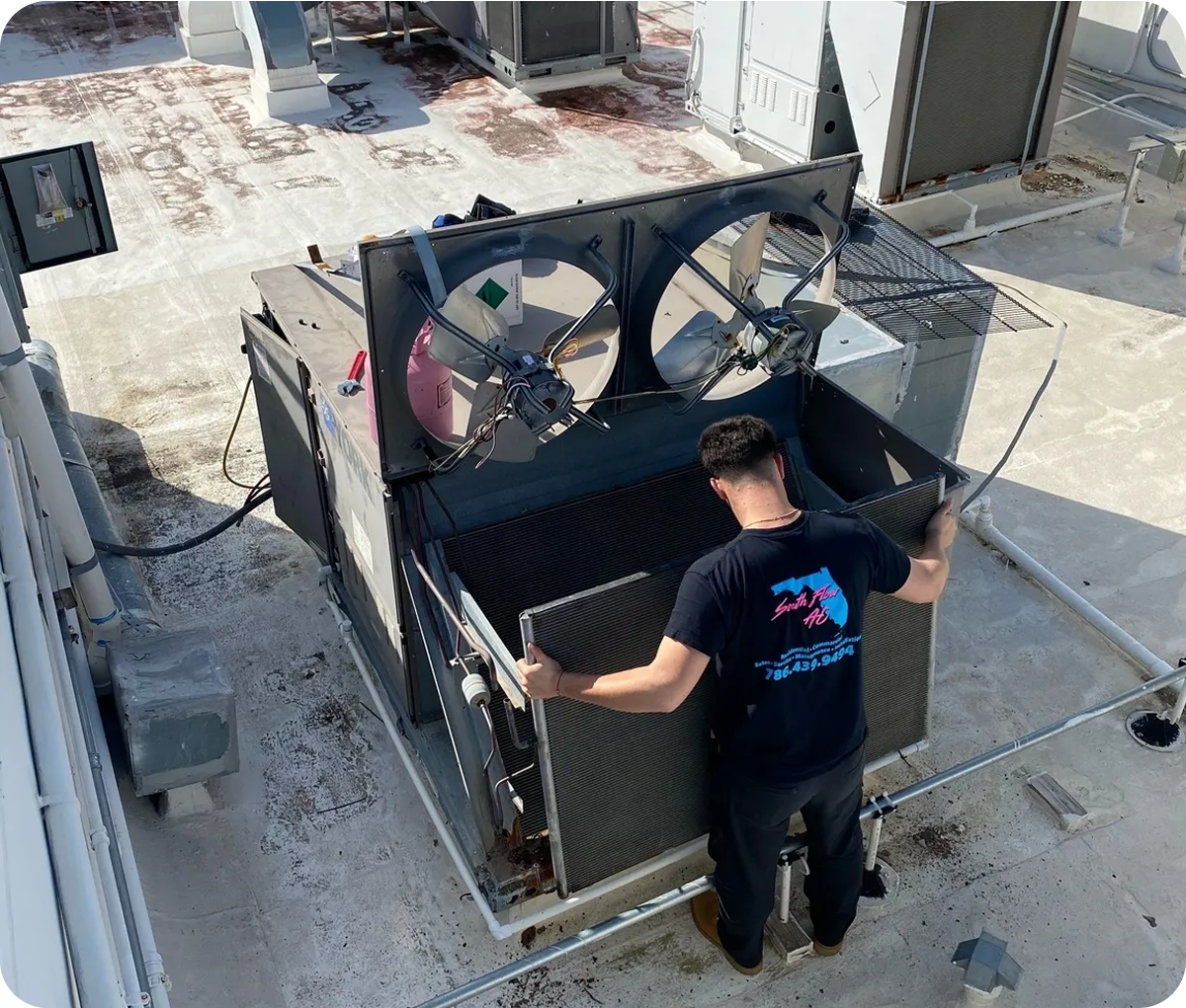Technician working on large industrial air conditioning unit outdoors