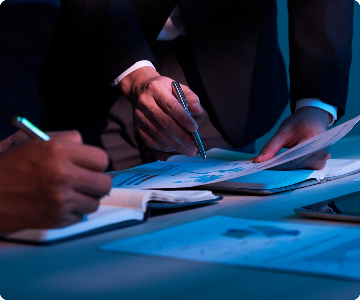 Business professionals reviewing and signing documents with blue lighting