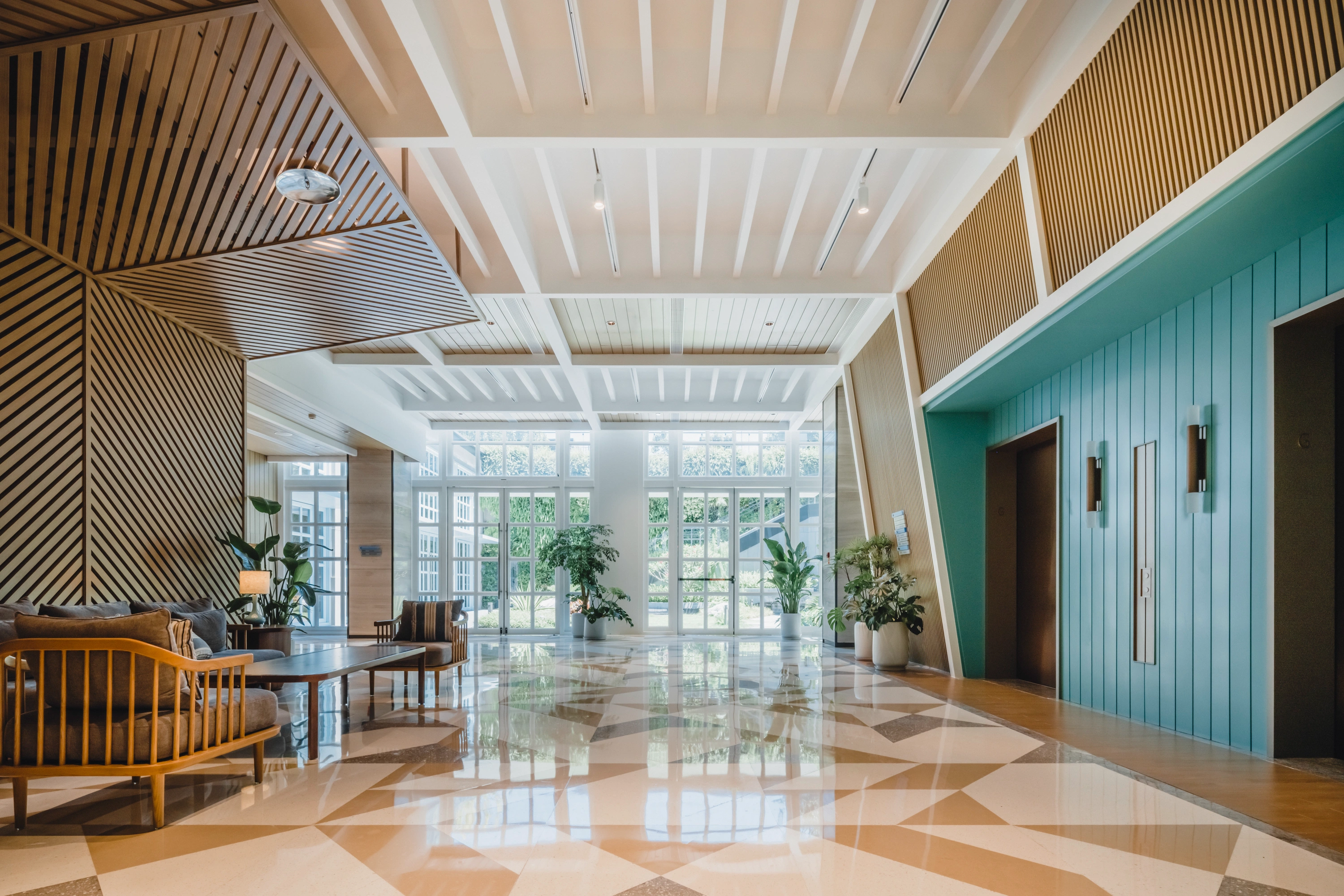 Island Club circulation zone at Hyatt Centric Xiamen with timber slatted ceiling, geometric stone flooring, and daylight-filled lobby seating