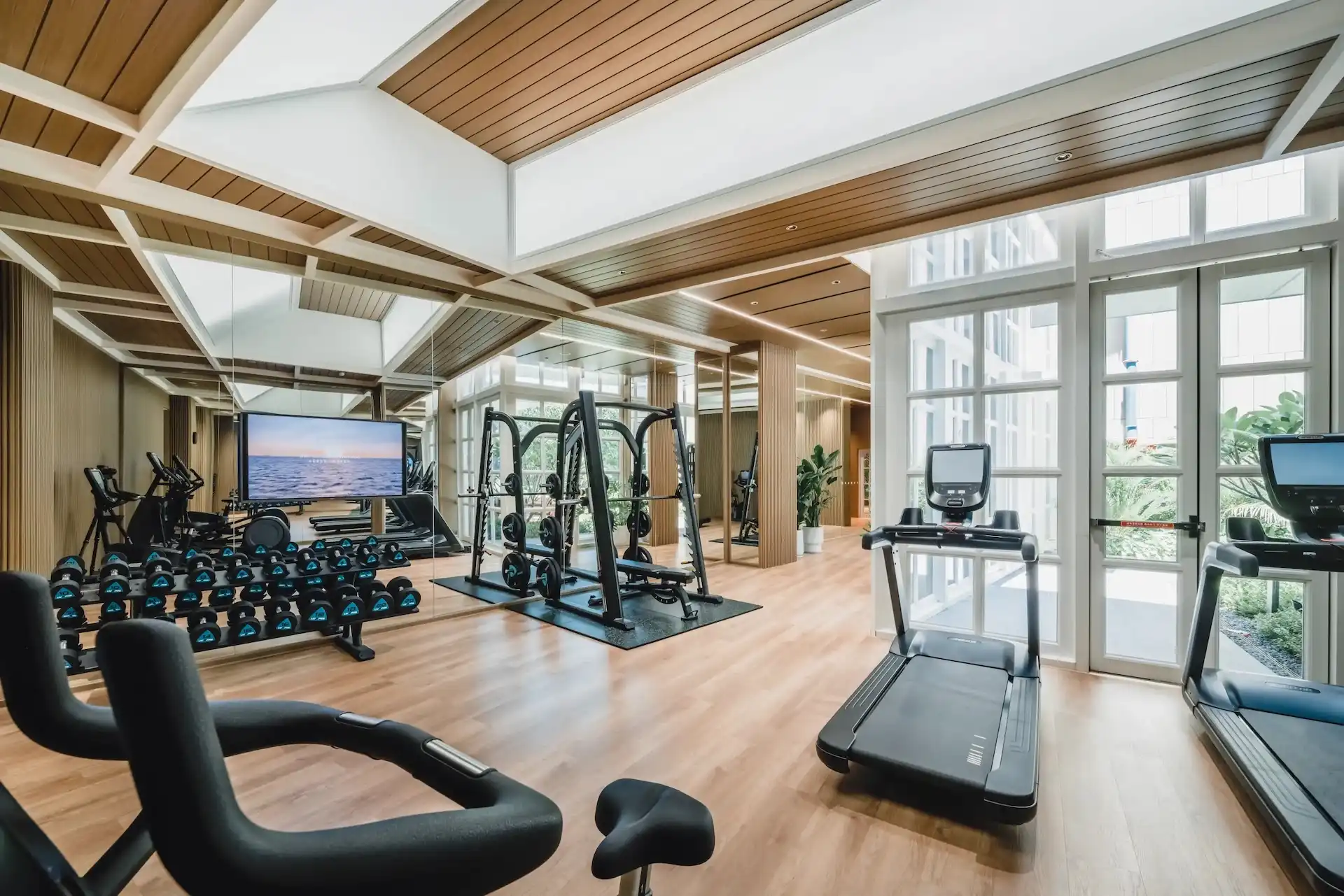 Hyatt Centric Xiamen hotel gym with modern fitness equipment, timber flooring and mirrored training wall