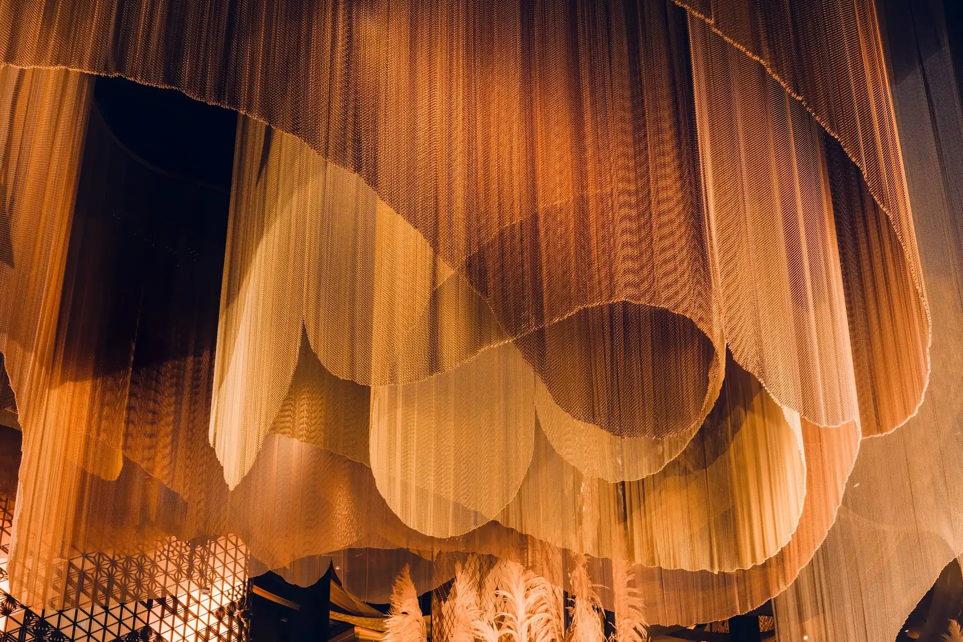 Strawfire Emirates Palace Abu Dhabi sculptural ceiling installation with layered mesh drapery and warm ambient lighting.