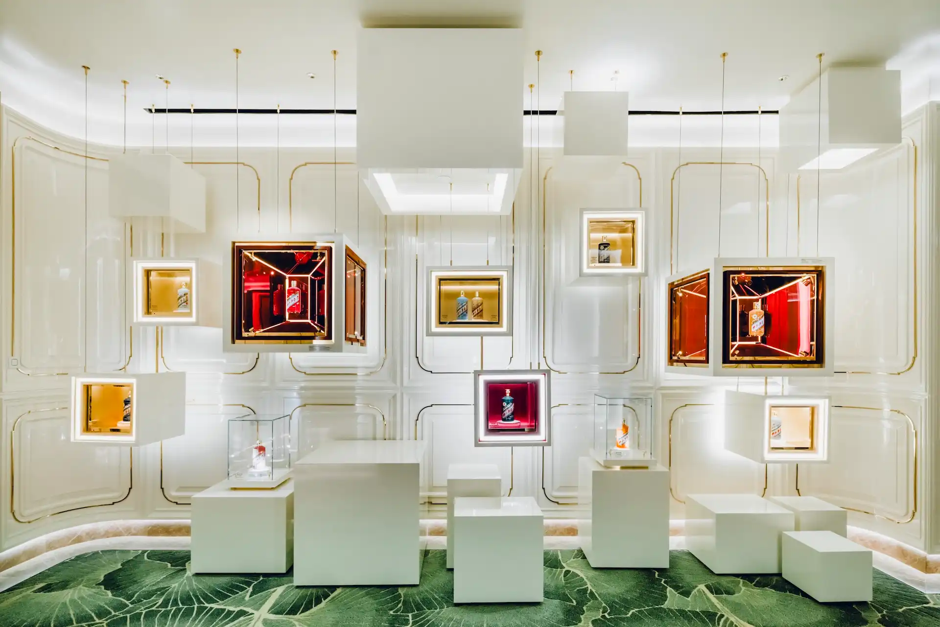 Grand Imperial Court Moutai art display installation at MGM Macao featuring suspended illuminated display boxes mirrored walls sculptural white plinths and bespoke leaf patterned carpet within a luxury Chinese restaurant interior