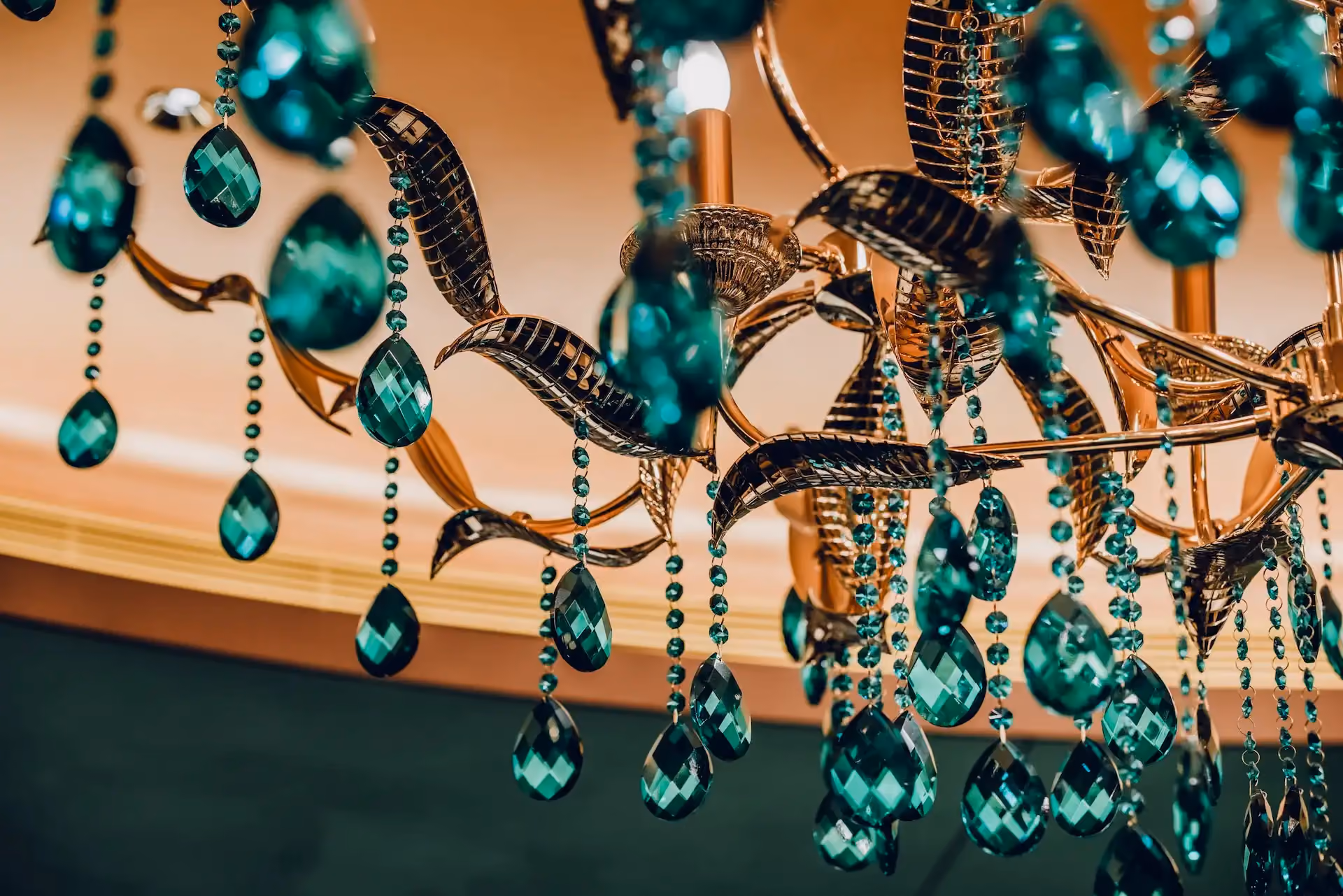 Grand Imperial Court emerald crystal chandelier detail at MGM Macao featuring faceted green glass drops beaded crystal strands and sculptural metal framework suspended beneath illuminated ceiling recess within a luxury Chinese restaurant interior design